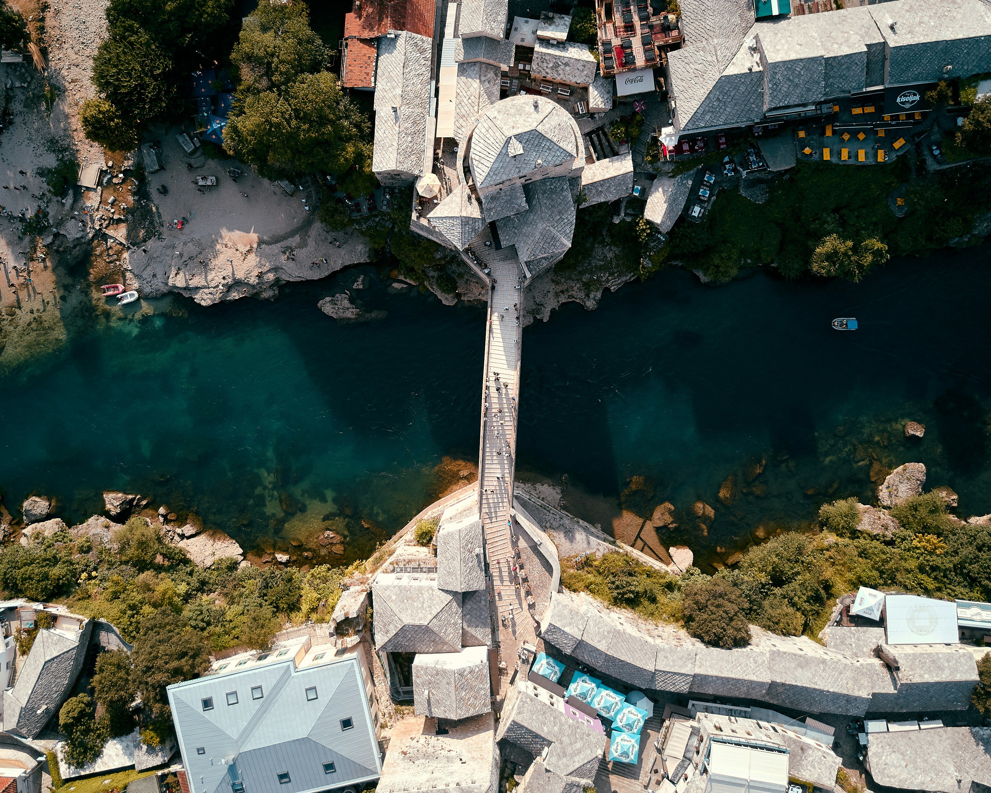 Mostar est sans doute l’image emblématique de la Bosnie-Herzégovine. Son célèbre pont en pierre, le Stari Most, reconstruit après la guerre, attire chaque année des milliers de visiteurs. Mais au-delà des clichés, Mostar dévoile une douceur de vivre étonnante. Entre ses ruelles pavées, ses maisons ottomanes et ses plongeurs téméraires sautant dans la Neretva, cette ville a su préserver son authenticité tout en s’ouvrant au monde.